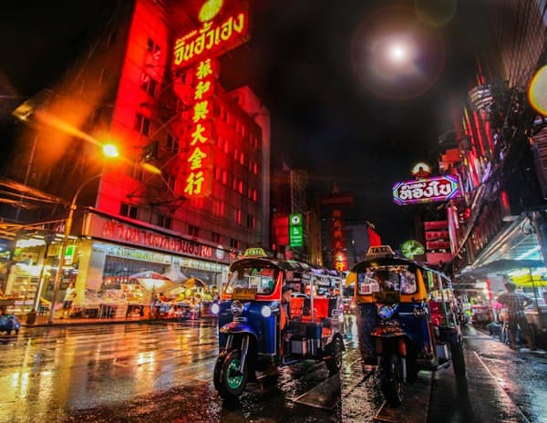 Tuk-tuks under neon signs in Bangkok's Chinatown at night
