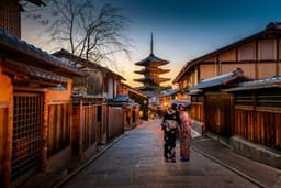 Two women in kimono on a street below the Yasaka pagoda in Kyoto at dusk